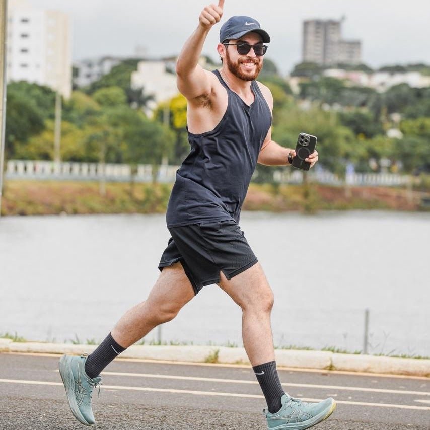 Barbosa correndo na orla de um lago, fazendo sinal de positivo